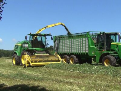 John Deere corn silage chopper filling a wagon pulled by a John Deere tractor